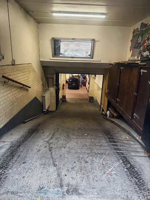 Nedfart från gatan till verkstaden med kaklade väggar och utsikt mot lyften längst in